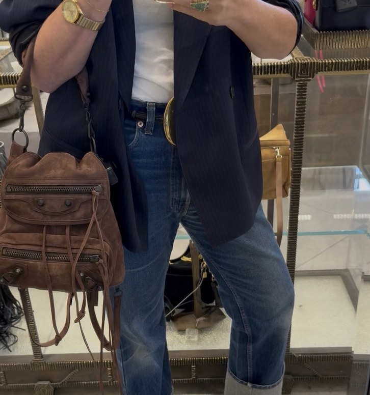 Mirror selfie in a pinstripe blazer, white tee and jeans with a brown suede backpack